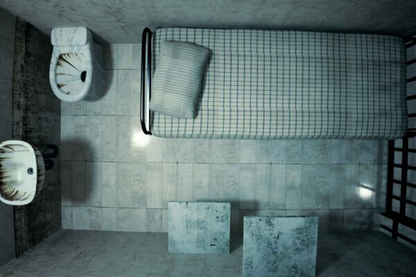 prison cell with bed and sink