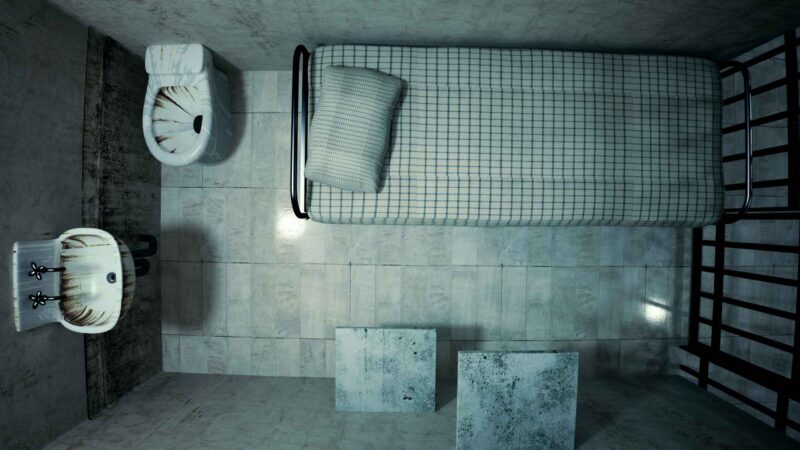 prison cell with bed and sink