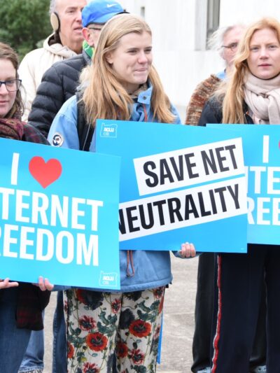 people holding signs that say i (heart) internet freedom and Save Net Neutrality on the capitol steps in Salem