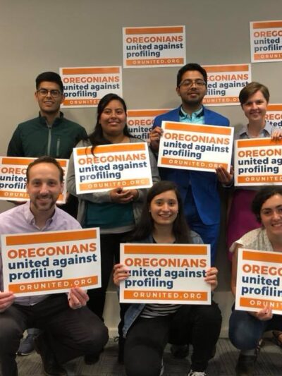 people gathered holding signs for Oregonians United Against Profiling