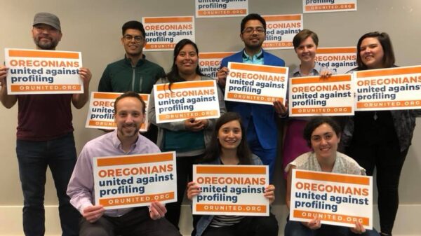 people gathered holding signs for Oregonians United Against Profiling