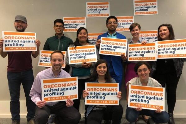 people gathered holding signs for Oregonians United Against Profiling