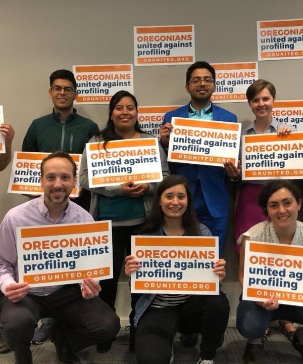 people gathered holding signs for Oregonians United Against Profiling
