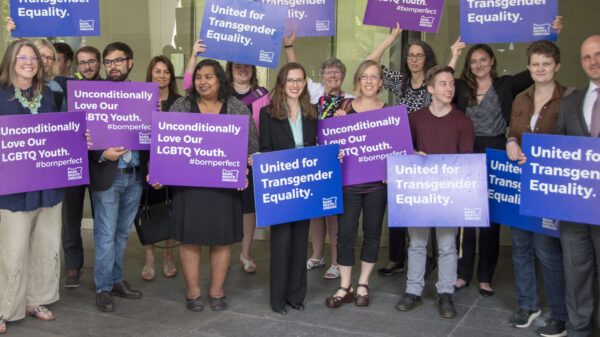 advocates outside court holding signs for transgender equality