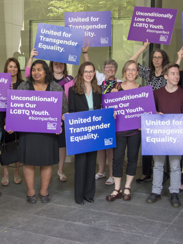 advocates outside court holding signs for transgender equality