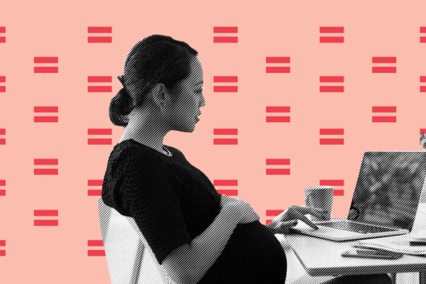 pregnant worker sits at desk with laptop