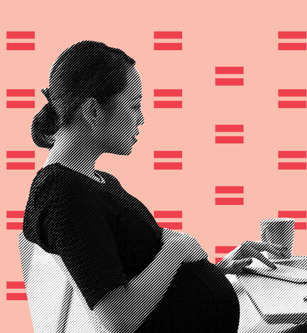 pregnant worker sits at desk with laptop