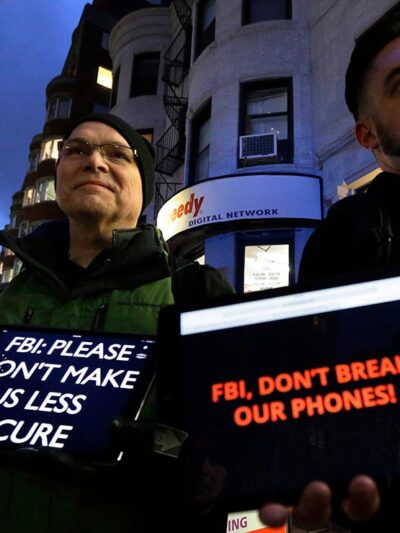 Demonstrators display iPads with the messages "FBI: Please don't make us less secure" and "FBI, don't break our phones!"