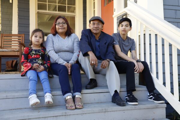 family on front steps of home