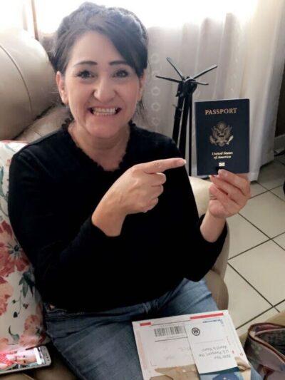 Maria Soto holds her passport and points to it