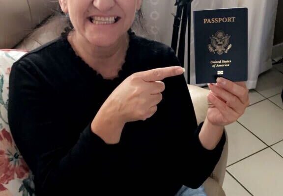 Maria Soto holds her passport and points to it