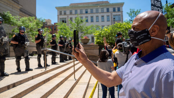 Man recording a line of police people
