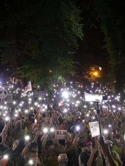 Thousands of protesters gather in downtown Portland in mid-July 2020. The authors write that People for Portland's call for additional police officers ignores the voices of thousands who marched for an end to systemic racism and police brutality.