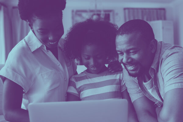 image of family grouped around a laptop