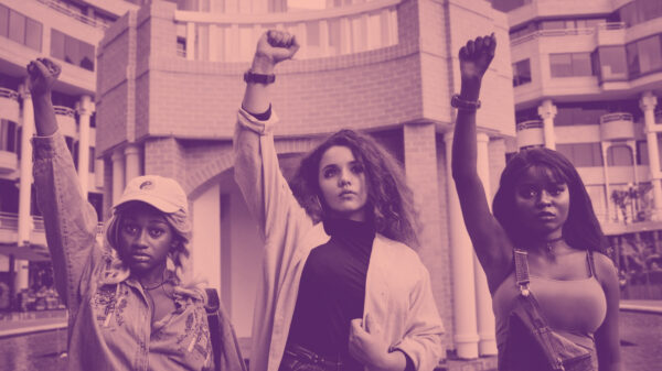 people in protest raising fists on pink background