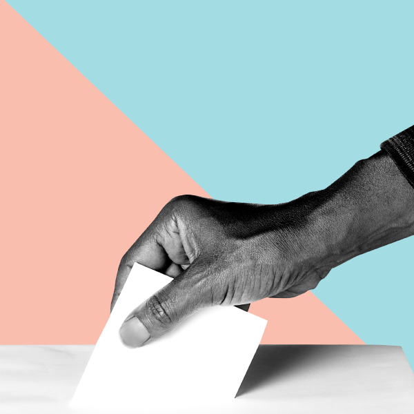 Hand placing ballot in box.