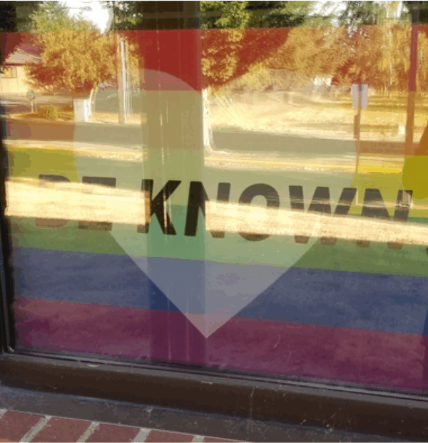 Rainbow sign with a heart and the words “Be Known” in Chelsea Shott's classroom window