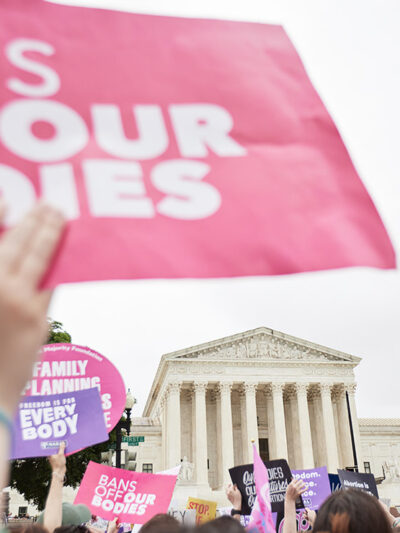 Protesters supporting abortion march in front of the Supreme Court holding signs that read "Bans off our Bodies."