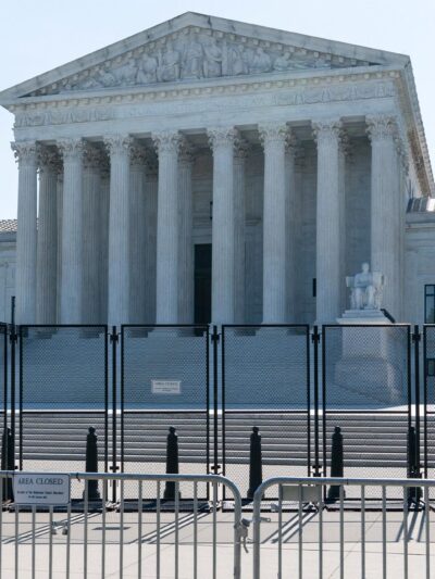 A view front of the U.S. Supreme Court Building behind riot gates.