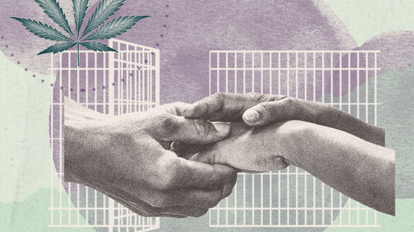 Hands clasped in front of open prison doors