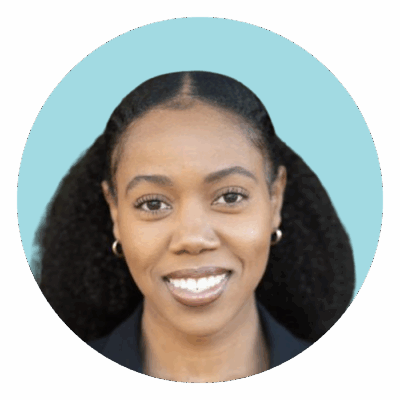 Alexandra smiling in front light blue background