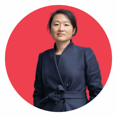 Sandy smiling in front of red circle background