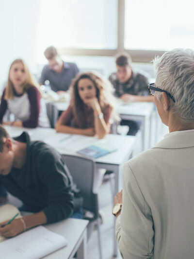 A professor in front of a class full of students.