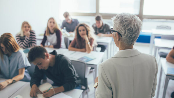 A professor in front of a class full of students.