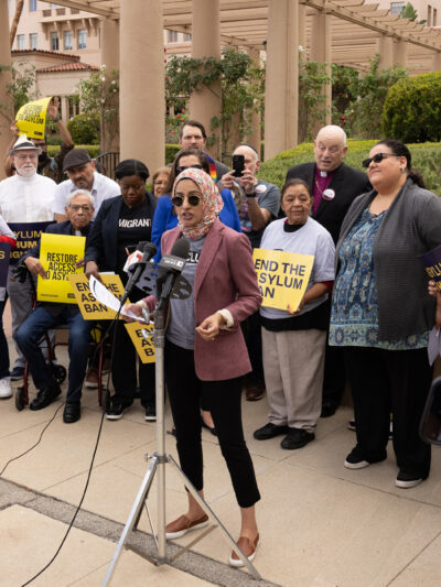 A woman speaking at a rally for asylum.