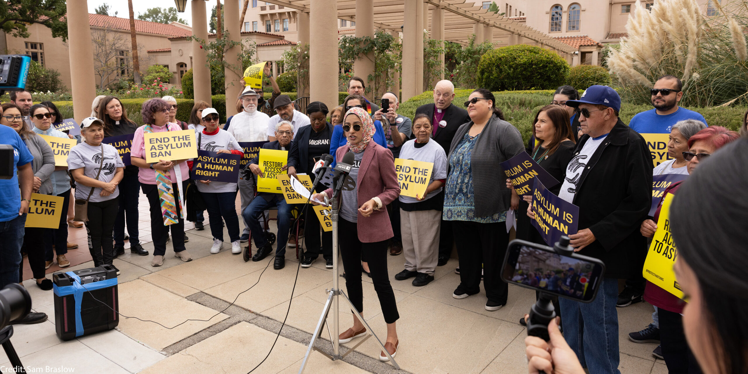 A woman speaking at a rally for asylum.