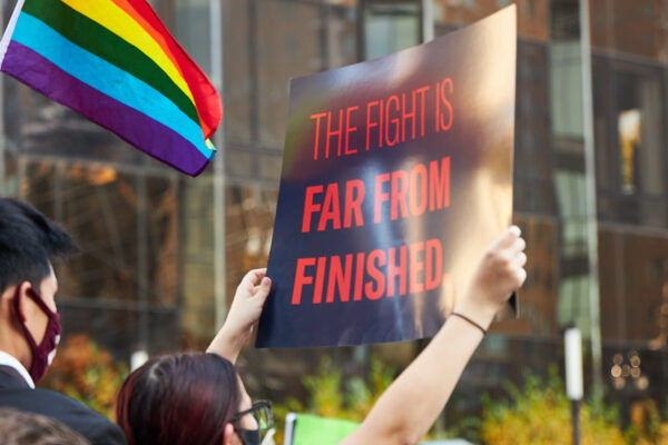 Someone holding a sign that says The Fight Is Far From Finished.