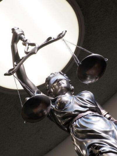 Image of brass statue holding scales in courtroom