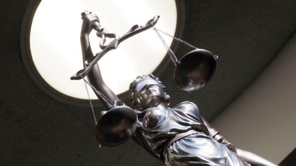 Image of brass statue holding scales in courtroom