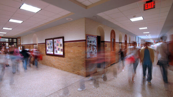 A group of kids moving in a school hallway.