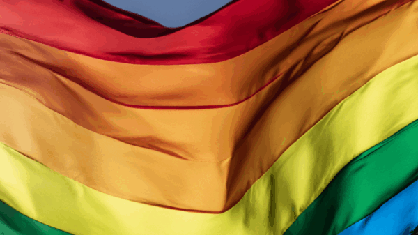 A rippling rainbow flag in the sky.