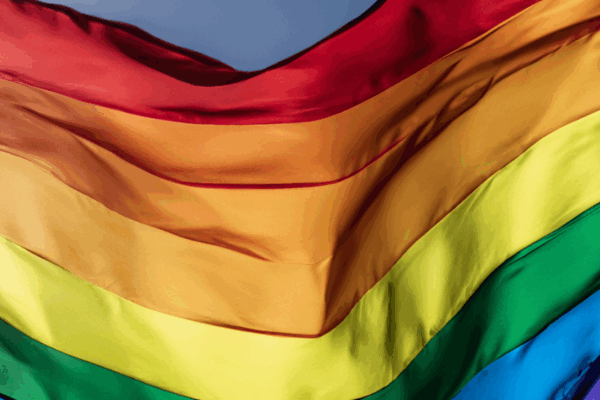 A rippling rainbow flag in the sky.