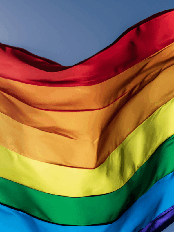 A rippling rainbow flag in the sky.