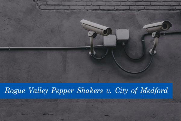 Image of white security cameras against a grey wall. At the bottom is a blue banner with the text, Rogue Valley Pepper Shakers v. City of Medford."