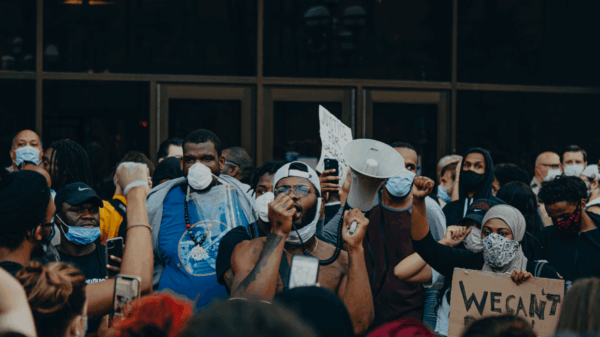 groups of protesters in front of glass doors.