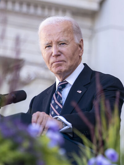 President Biden stares into the camera from behind a podium.