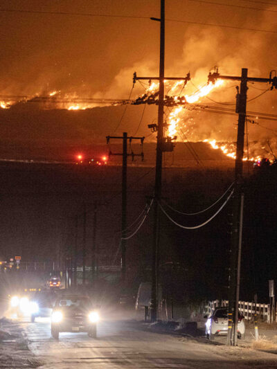 Hughes fire, in Castaic, burns on a hill threatening the freeway below while cars attempt to escape.