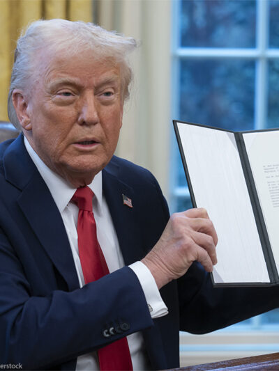 President Donald Trump holds up a recently signed executive order in the Oval Office of the White House.