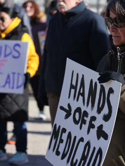 Demonstrators holding signs that read "HANDS OFF MEDICAID" protest the Trump administration's plan to roll back Medicaid expansion during a rally in front of the DuPage County Court House in Illinois.