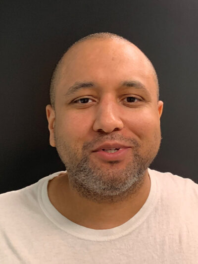 Mikal Mahdi headshot wearing a white tee shirt.