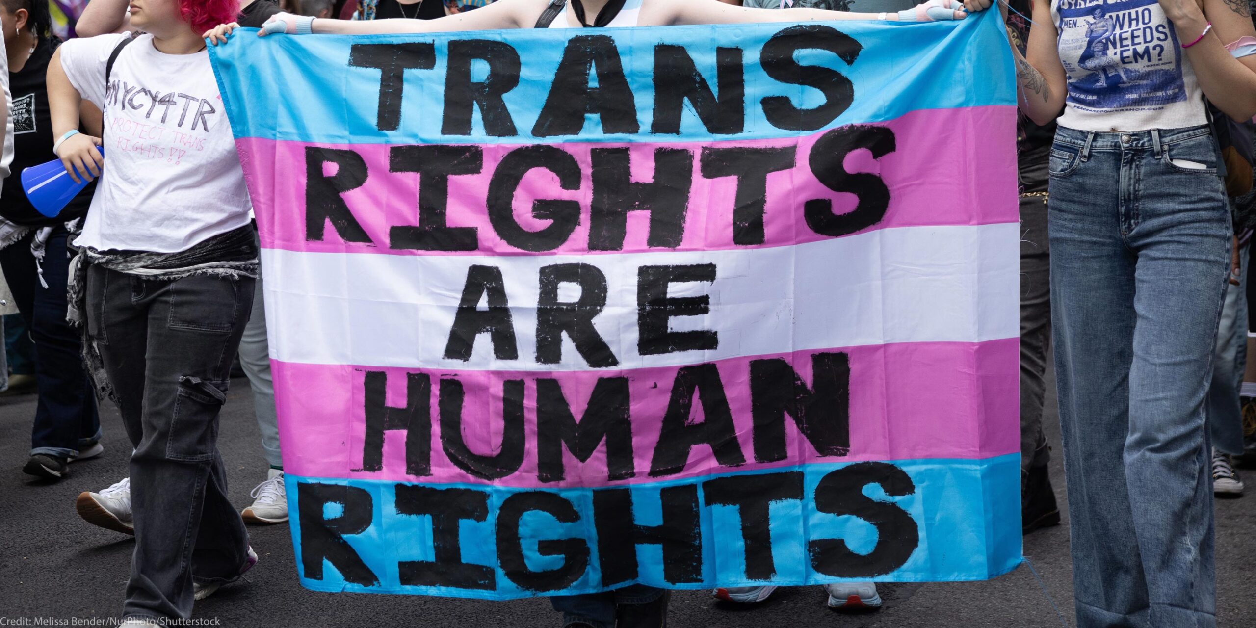 Trans Rights, speakers, protesters, and supporters denounce the Trump Administration's persistent attacks on the transgender community. by carrying a huge sign reading" TRANS RIGHTS ARE HUMAN RIGHTS".