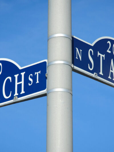 Two street signs at an intersection on a pole reading Church St on one and State St on the other.