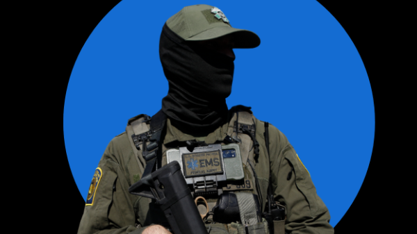Image of a police officer wearing a black mask covering all of their face.