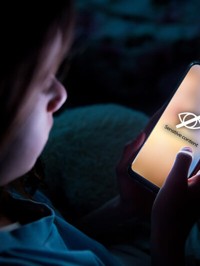 A child using smart phone in bed late at night.