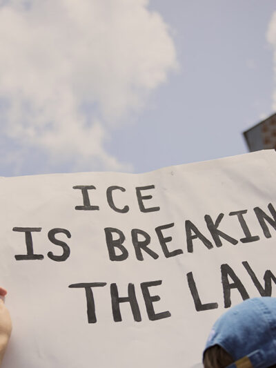 A demonstrator at the Journey to Justice rally in Basile, Louisiana on June 30, 2025 holding a sign that says, "ICE is Breaking The Law."