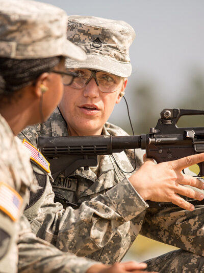 A woman Drill Sergeant candidate given instruction by a women Drill Sergeant instructor.